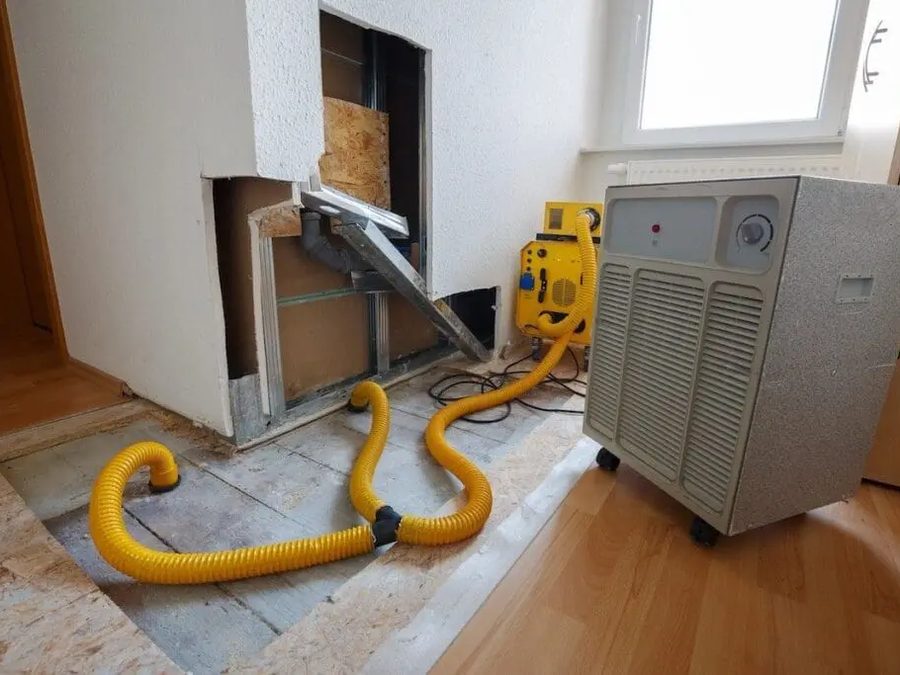 Air movers and a dehumidifier drying a water damaged room